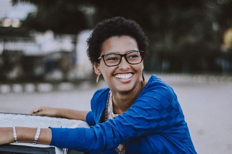 woman beside white vehicle during daytime